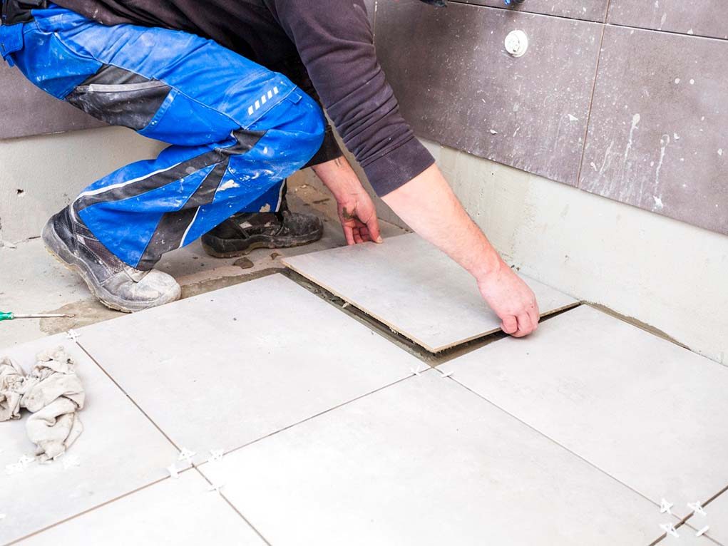 Subway tile being installed over a waterproofing membrane on a shower wall, Miami